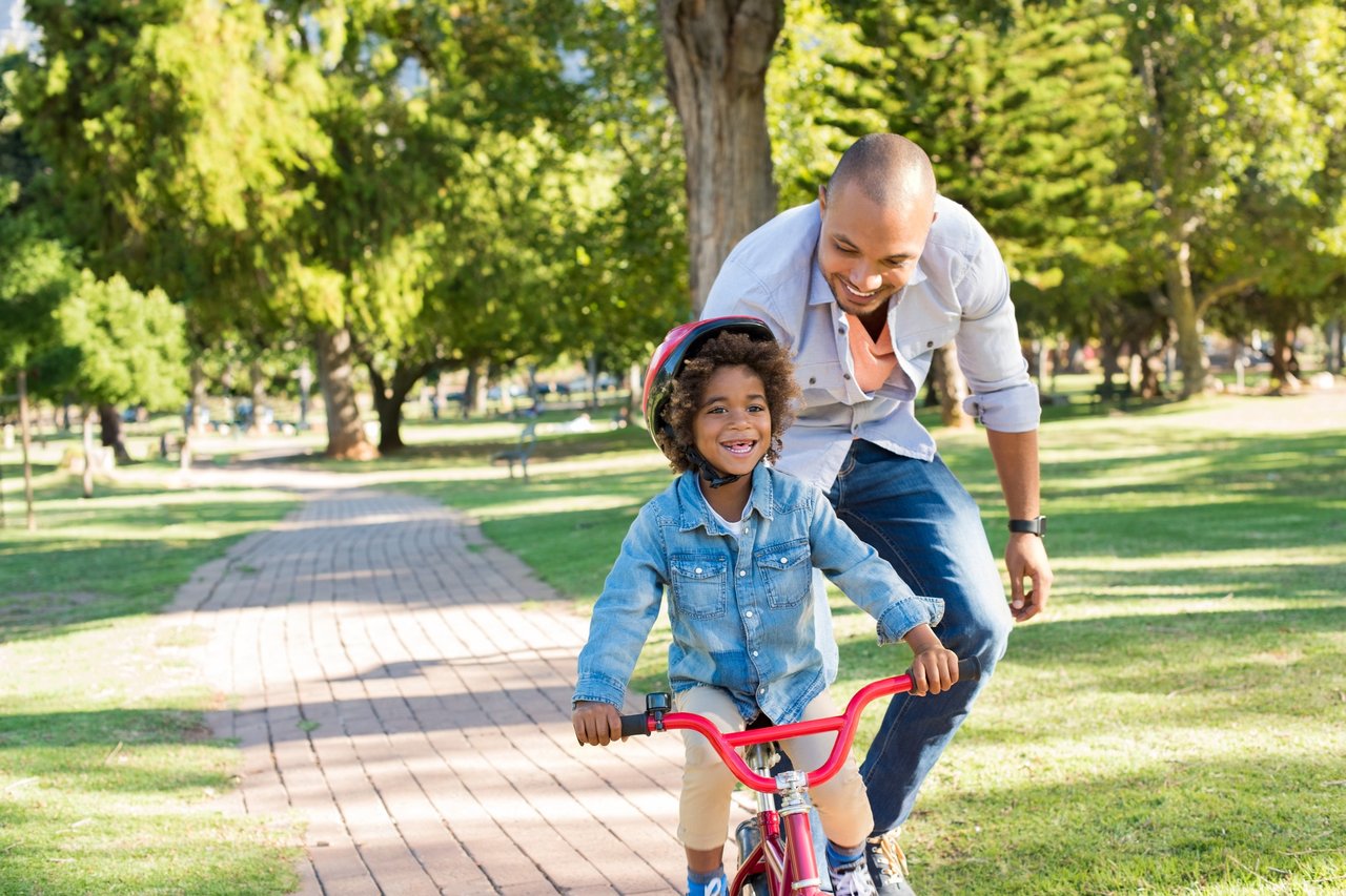 Father teaching son cycling in a park