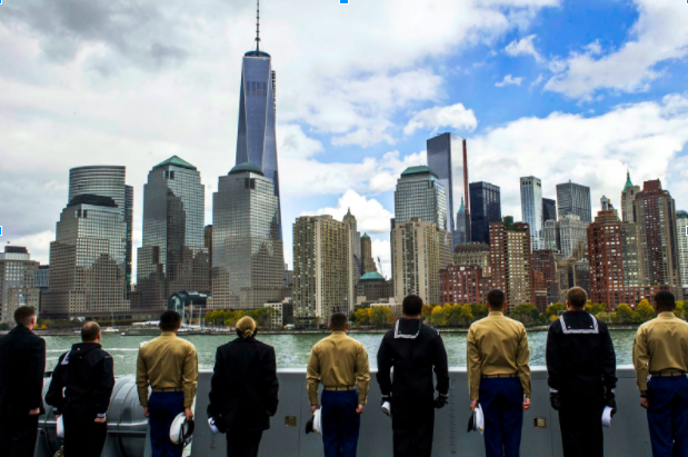 Navy servicemembers with hats off look onto New York City and the World Trade Center